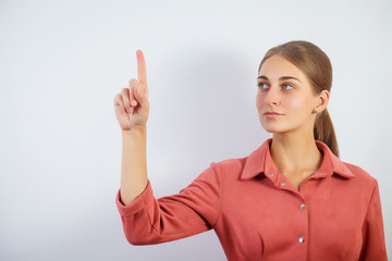 Woman touching an imaginary screen with her finger.Portrait of female college student touching...