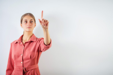 Woman touching an imaginary screen with her finger.Portrait of female college student touching something on copy space.Attractive young woman touching a virtual interface with her finger