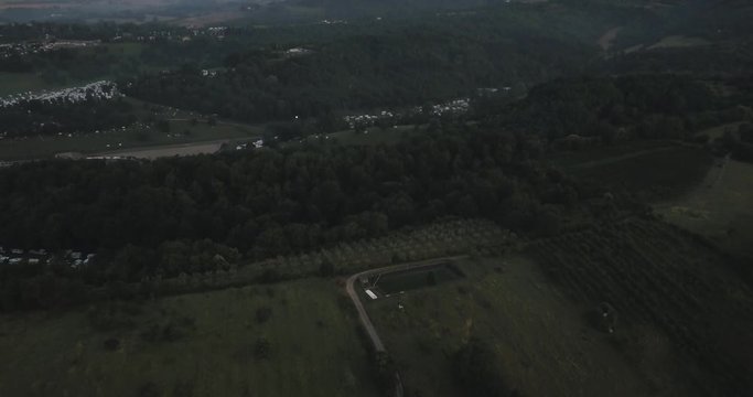 Aerial Drone view of Italian countryside during sunrise with mountains and forest