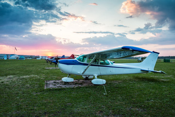 Small private aircrafts parked at the airfield at scenic sunset