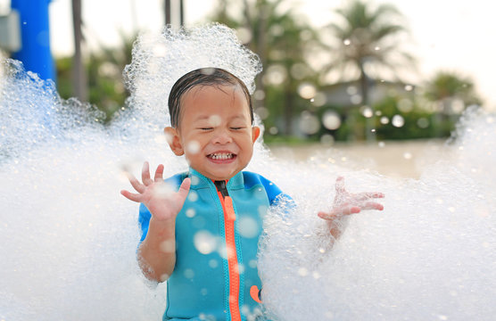 Portraits Of Happy Little Asian Baby Boy Smiling Having Fun In Foam Party At The Pool Outdoor.