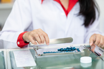 asian pharmacist drug counting on counter in pharmacy