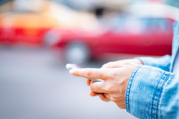 asian man using smartphone with blurred city street