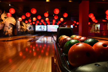 Bowling lane and balls in the row in bowling center. - obrazy, fototapety, plakaty