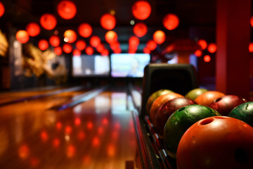 Bowling lane and balls in the row in bowling center. - obrazy, fototapety, plakaty