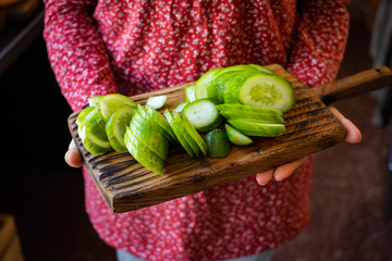 Cut fresh green cucumbers on wooden board
