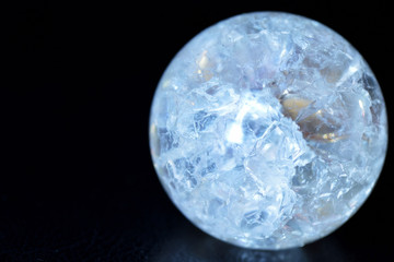 Glowing crystal ball with cracks inside on a dark background. The process of predicting the future