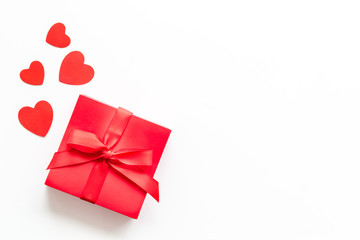 Gift to a sweetheart on Valentine's Day. Red present box near hearts on white background top-down copy space