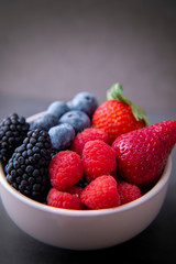 strawberries, blueberries, blackberries and raspberries in the bowl