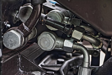 Hydraulic and pneumatic fittings on pressure distributor tractor engine close up