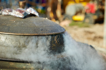 Steam coming out from traditional iron cooking pot 