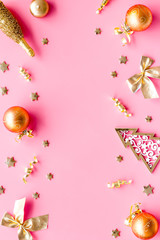 New Year mockup in gold color. Champagne bottle, present box, decoration, balls on pink background top-down frame copy space