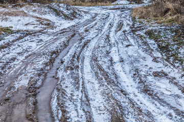 The bad ground or soil rural or suburb road or way with puddles, pools, mud and slush