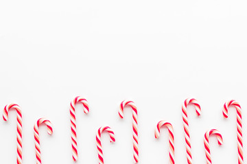 Christmas candies frame - cane with red and white stripes - on white background top-down copy space