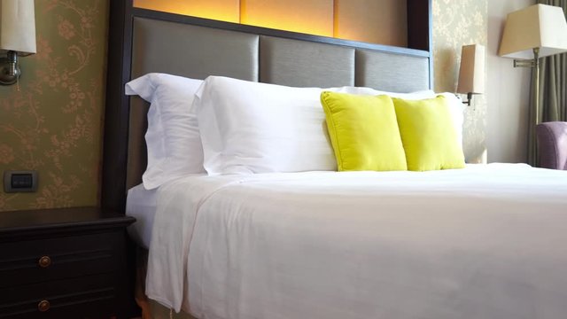 Pan across a well-appointed resort hotel room and bed.