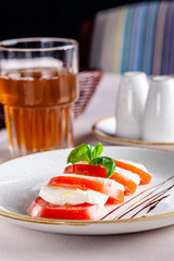 Italian food concept. Caprese salad of tomato and cheese with basil in a restaurant. Copy space, background image