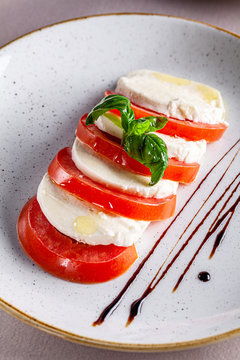 Italian food concept. Caprese salad of tomato and cheese with basil in a restaurant. Copy space, background image