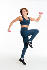 itness middle aged asian woman blue sweatpants and top jumps. Isolate white background with pink dumbbells
