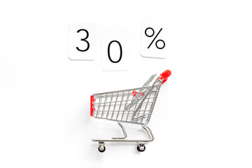 30% off discount - sale concept with shopping trolley cart - on white background top-down copy space