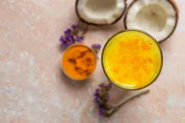 Masala Haldi Doodh. Healthy vegetarian coconut golden milk with turmeric and honey on a beige marble background.