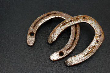 Old horseshoe  lying on black shale, it is it is an expression of happiness and cohesion