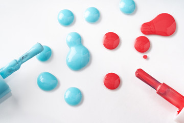 Drops of spilled nail polish over white background
