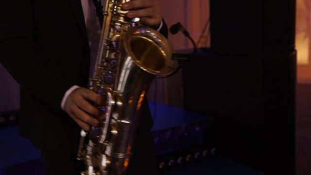 Saxophonist in a concert jacket plays the saxophone. Live show. Jazz.sax.Slow Motion