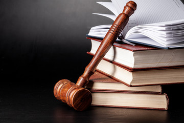 Wooden gavel and juridical books close up