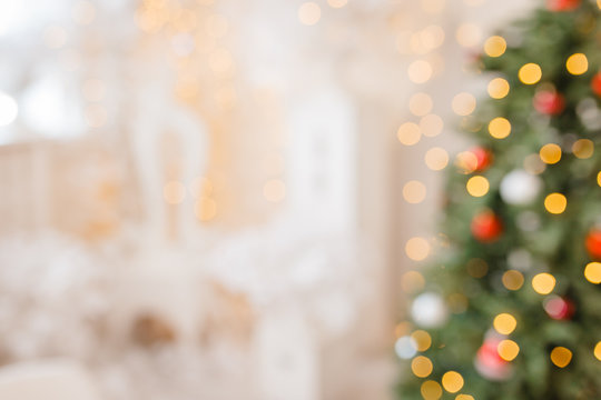 Christmas home room with tree and festive bokeh lighting, blurred holiday background. New year background