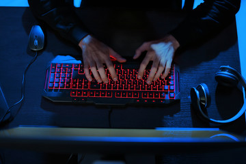 Professional hacker using computer in dark room