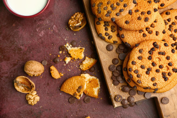 Tasty cookies with chocolate chips on color background