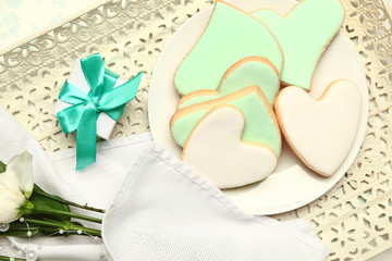Plate with tasty heart-shaped cookies, gift and flowers on tray. Valentines Day celebration