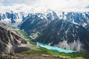Spectacular view to scenic valley with big beautiful mountain lake surrounded by giant snowy ranges and glaciers. Amazing atmospheric highland landscape. Wonderful majestic wilderness nature scenery.
