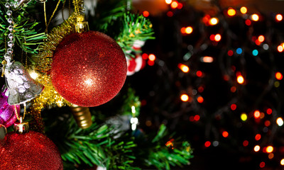 red ball and Ornaments on christmas tree with bokeh of lights