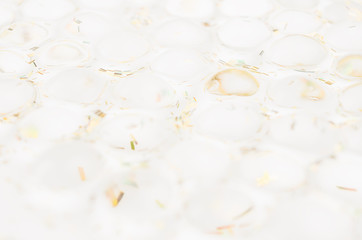White transparent circles with golden glitter as elegant light abstract background.
