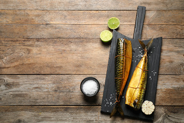 Tasty smoked fish on wooden table, flat lay. Space for text