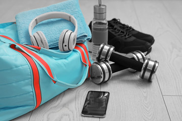 Sports bag and gym stuff on wooden floor