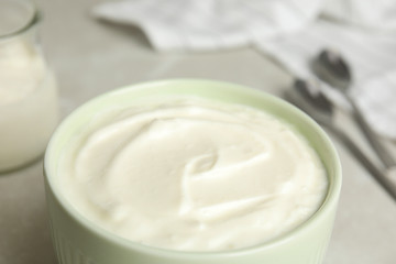 Tasty organic yogurt in bowl on table, closeup