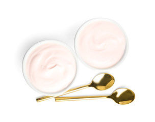 Tasty organic yogurt in bowls and spoons isolated on white, top view