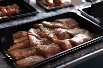Fresh marinated fish in container on display, closeup