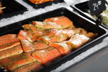Fresh marinated fish in container on display, closeup