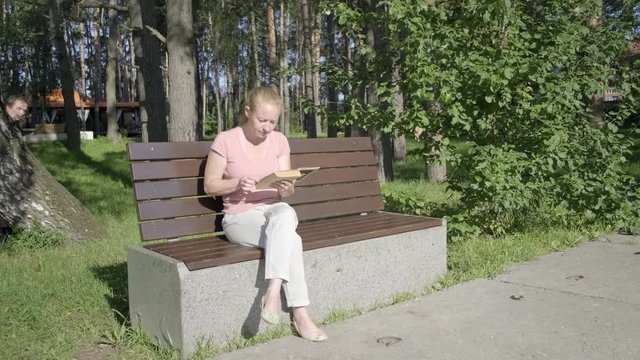 exhibitionist watches victim in park. girl sits on bench and reads book when maniac follows her.
