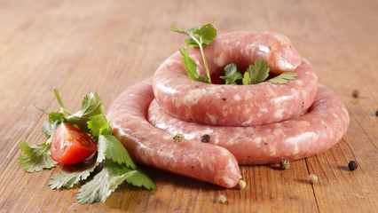 sausage with herbs and tomato on wood background