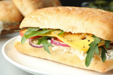 Delicious sandwich with fresh vegetables and cheese on light table, closeup