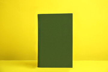 Hardcover book on yellow background. Space for design