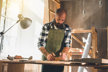 Portrait of a young male carpenter who works in his workshop.