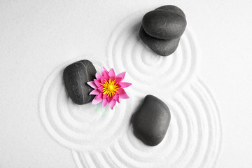 Zen garden. Beautiful lotus flower and stones on white sand, flat lay