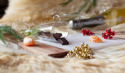 Chocolate bars in a champagne glass and piece of mandarin.  Christmas and New Year composition.