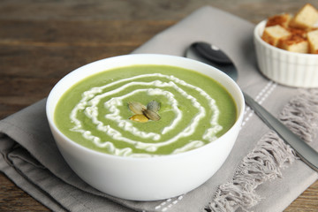 Delicious broccoli cream soup served on wooden table