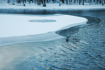 Partially frozen lake in the park- cold season background